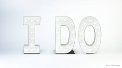 White marquee letters spell "I DO" on a plain background.